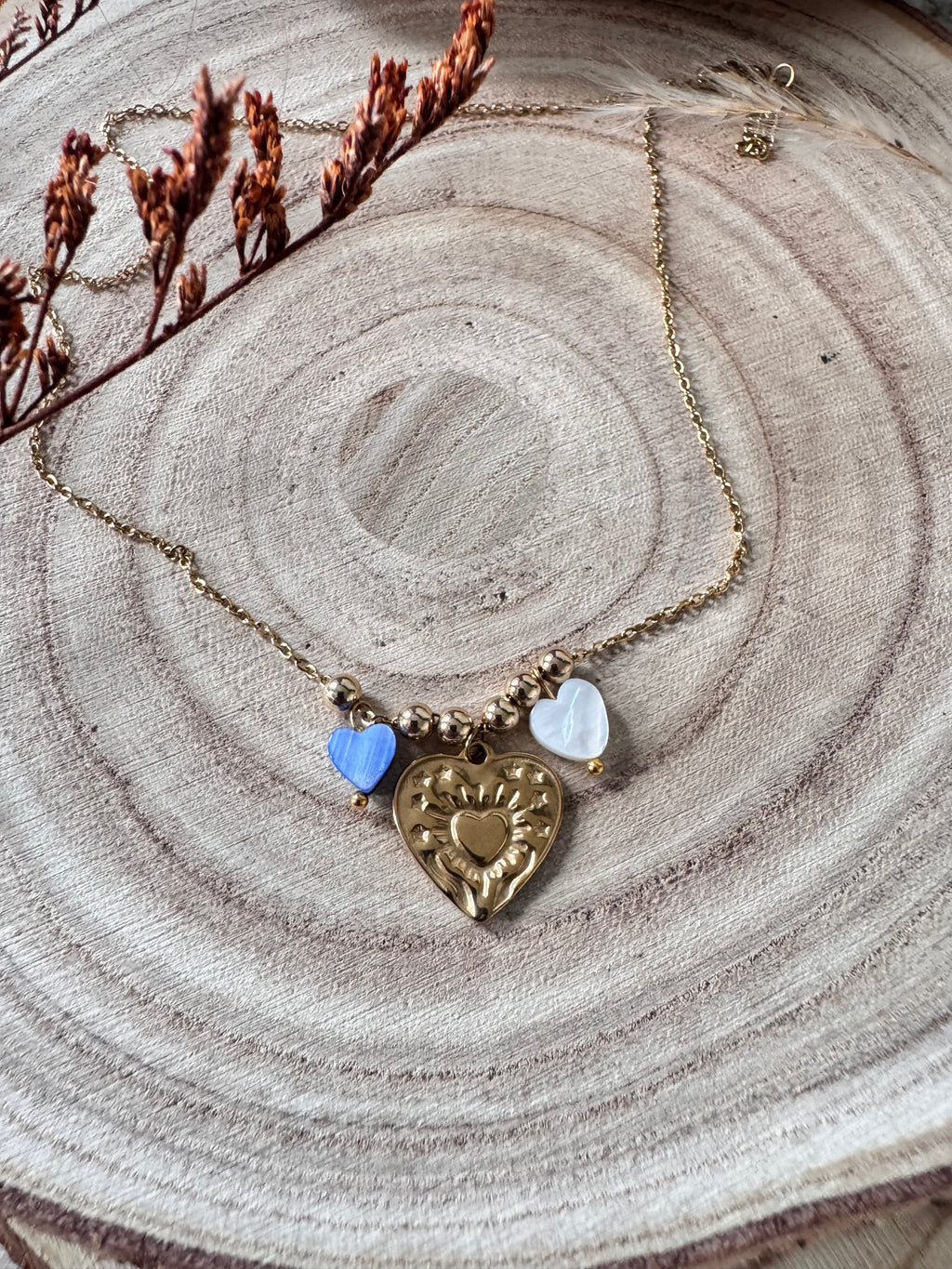 Collier Amour doré porté près du cou, charm cœur doré et perles cœur en coquillage naturel bleu et blanc