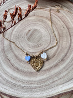 Collier Amour doré porté près du cou, charm cœur doré et perles cœur en coquillage naturel bleu et blanc