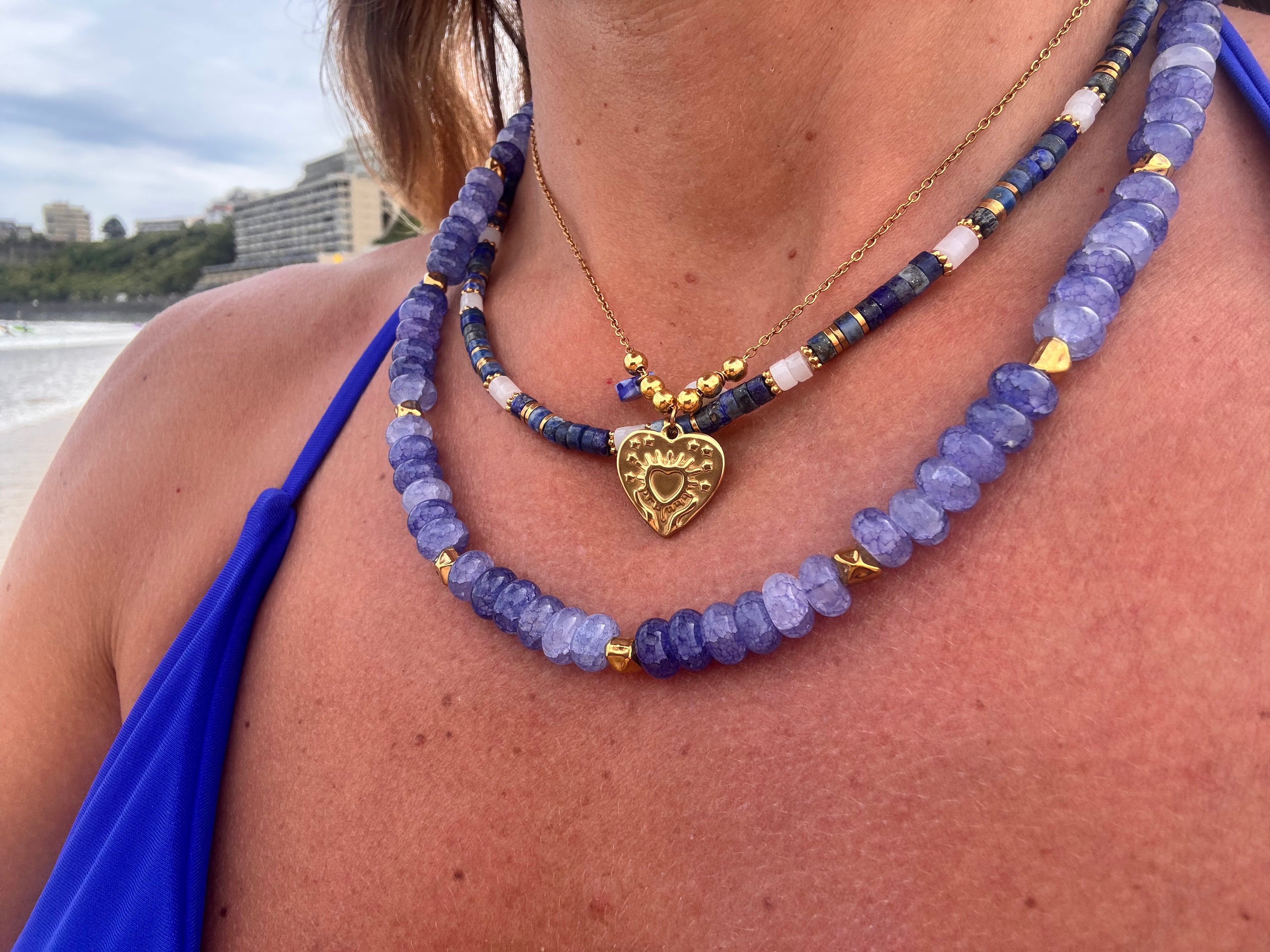 Collier Amour doré porté en superposition avec d'autres colliers fins dorés