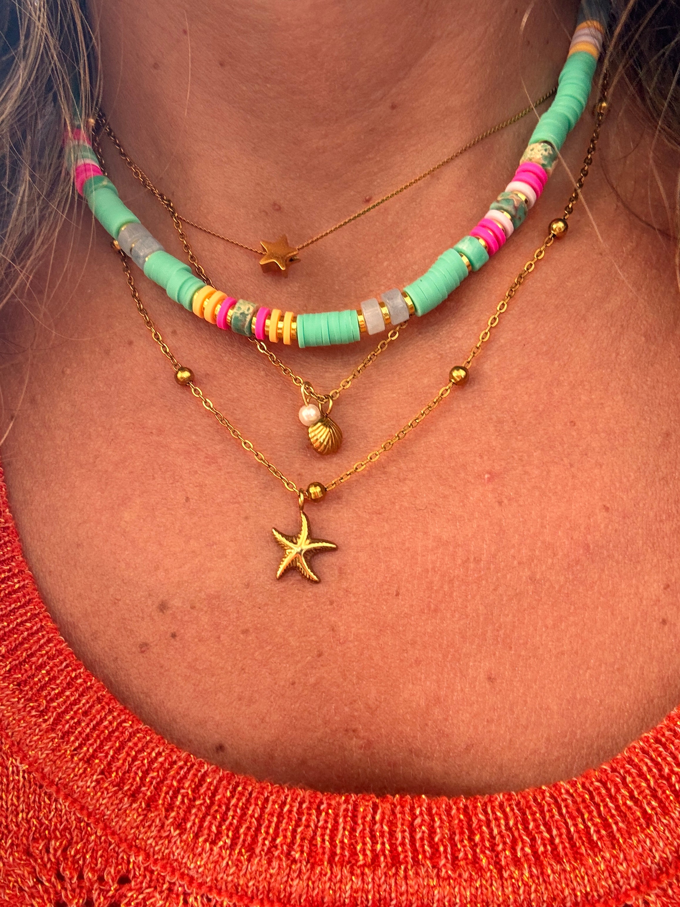 Collier Cosma en acier inoxydable avec perles heishi et coquillage naturel, posé à plat