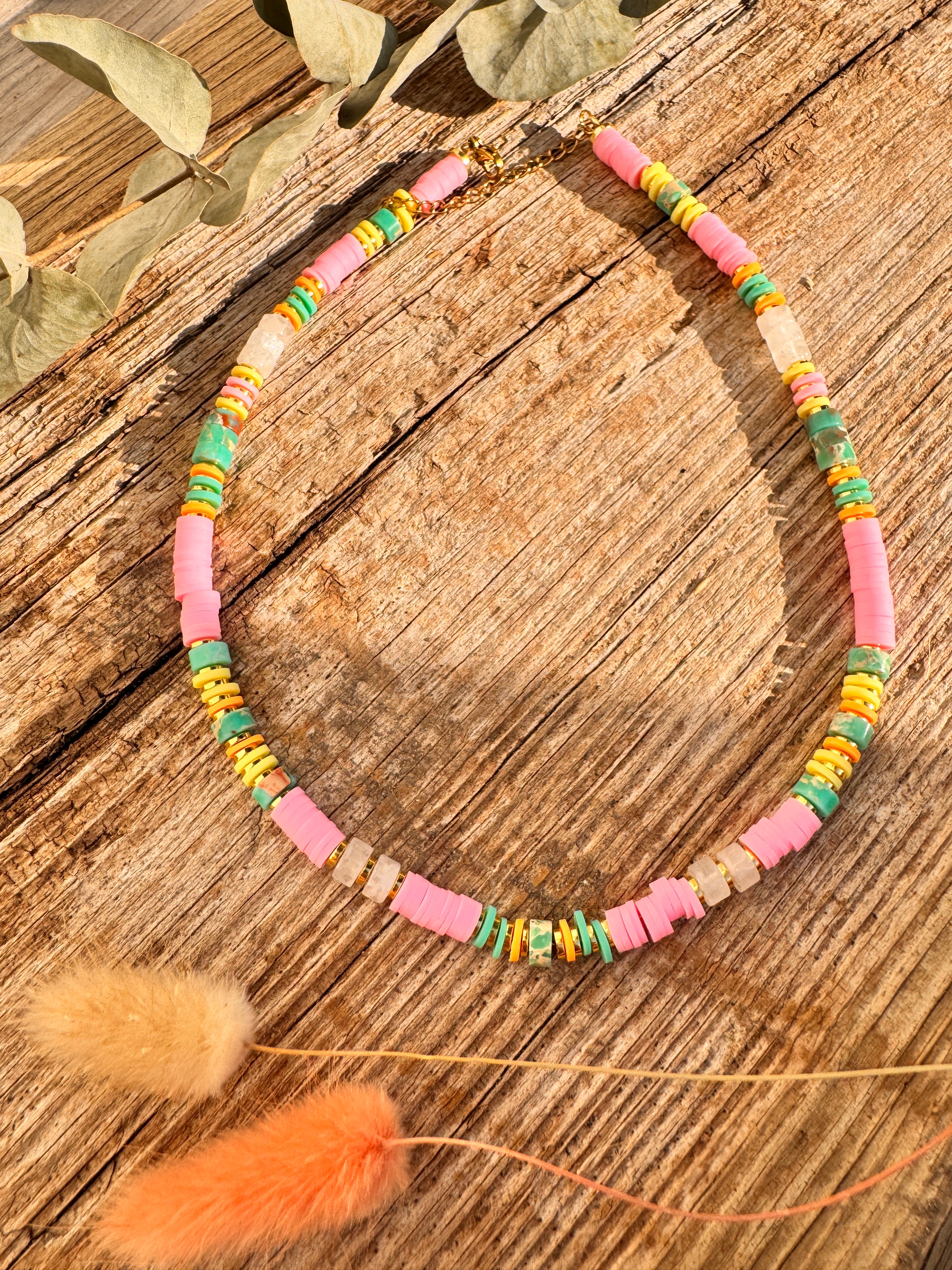 Collier Luluhey en perles heishi multicolores rose, jaune et turquoise, posé à plat