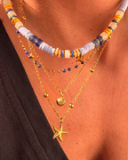 Collier heishi bleu et orange superposé avec chaînes coquillage et étoile de mer