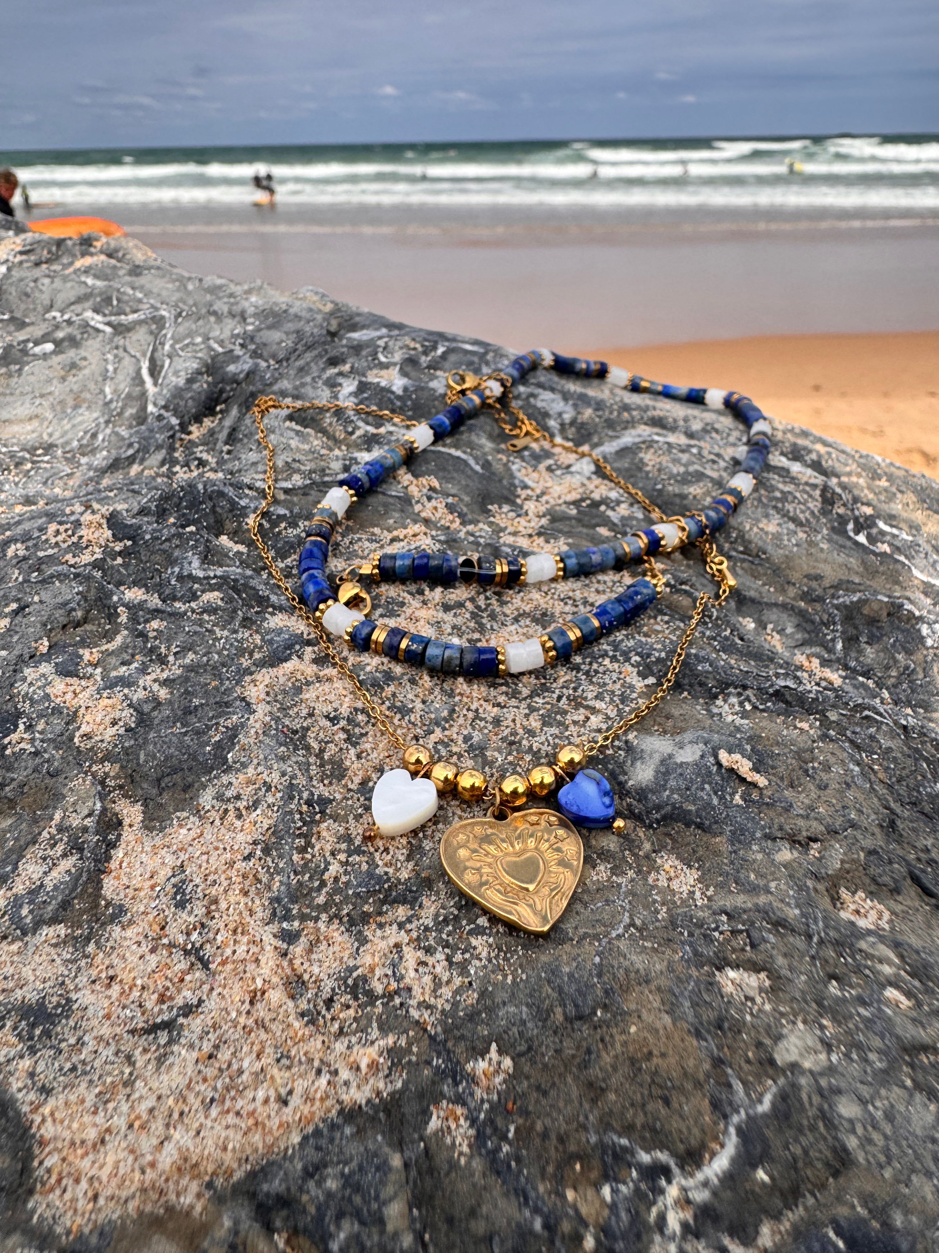 Perles en forme de cœur en coquillage naturel bleu et blanc sur la chaîne dorée du collier Amour