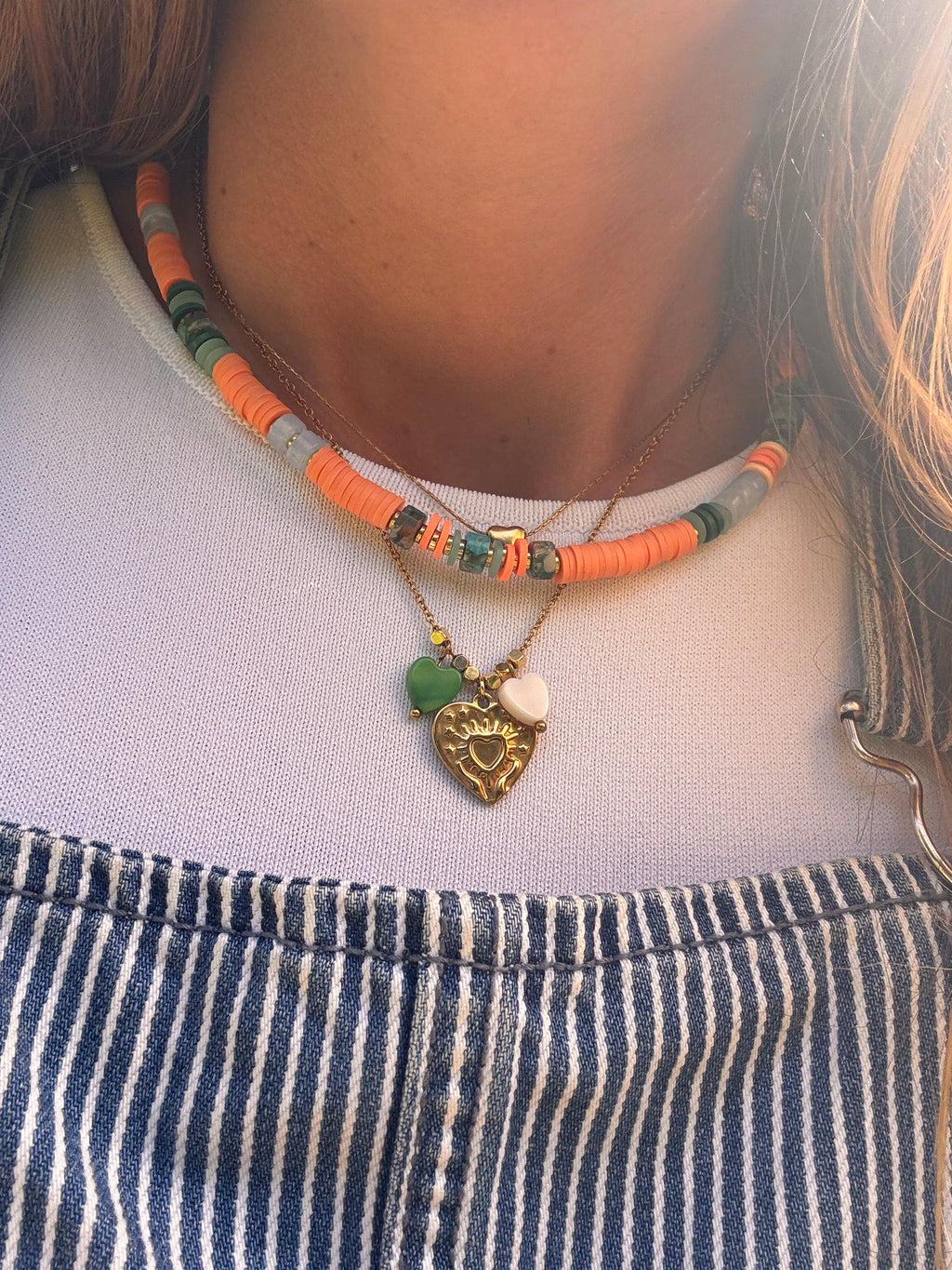 Perles en forme de cœur en coquillage naturel vert et blanc sur la chaîne dorée du collier Amour
